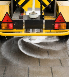Salt on sidewalk A machine is sprinkling salt on a sidewalk